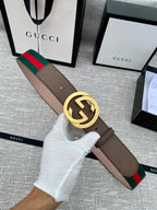 Gucci belt with brown leather strap, gold-tone double G buckle, and green-red web stripe trim.
