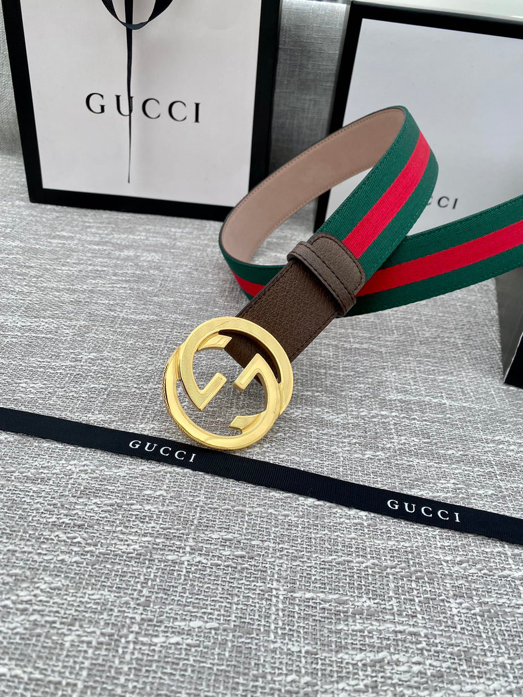 Gucci belt with brown leather strap and gold-tone double G buckle, set with green-red web stripe.