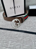 Gucci belt with brown leather strap, silver-tone double G buckle, and green-red web stripe.