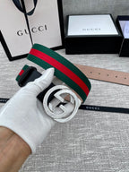 Black leather belt with silver-tone GG buckle and green-red web stripe close-up