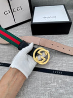 Black leather belt with gold-tone GG buckle in hand, green-red web stripe