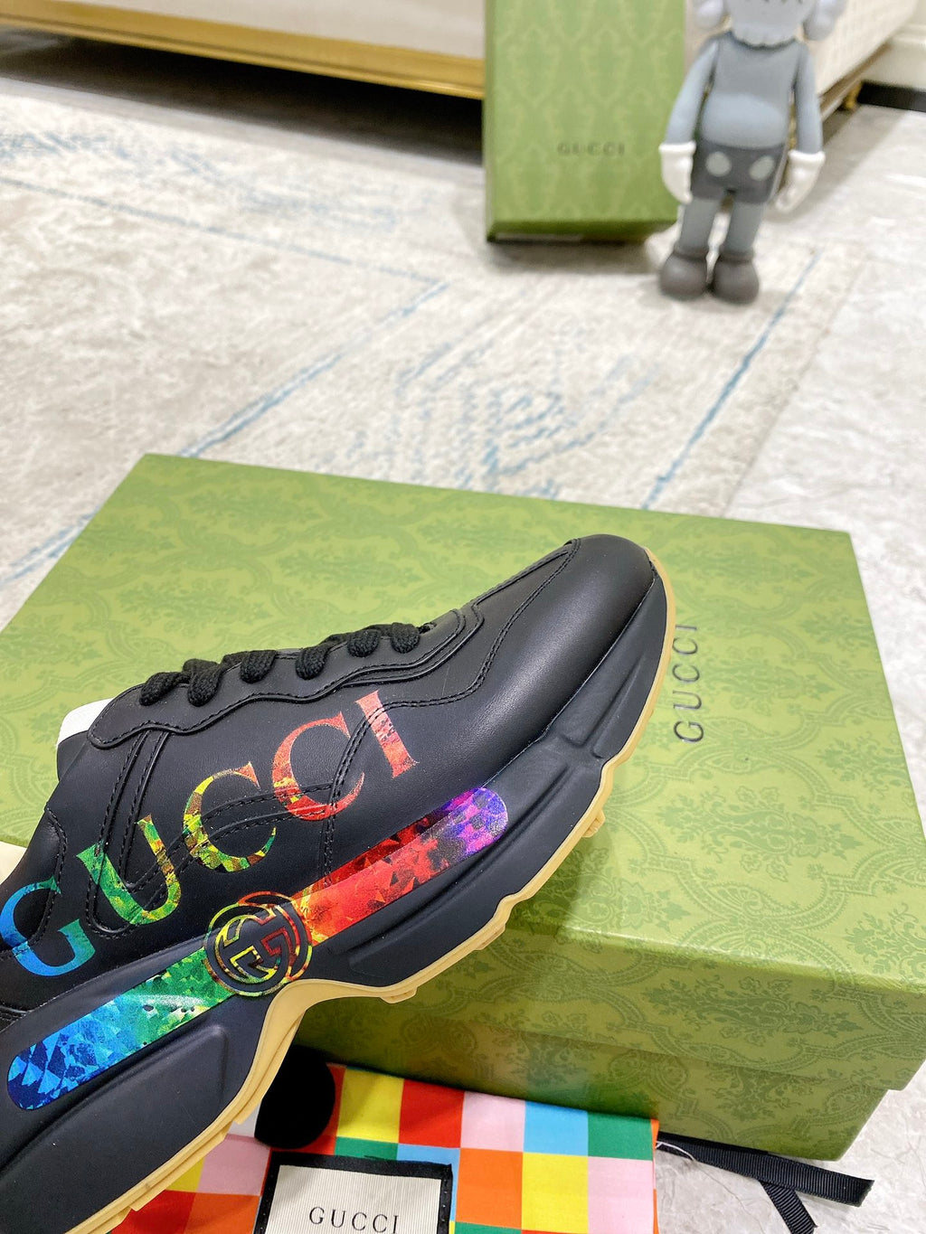 Black Gucci low-top sneaker with multicolor web logo stripe and round emblem