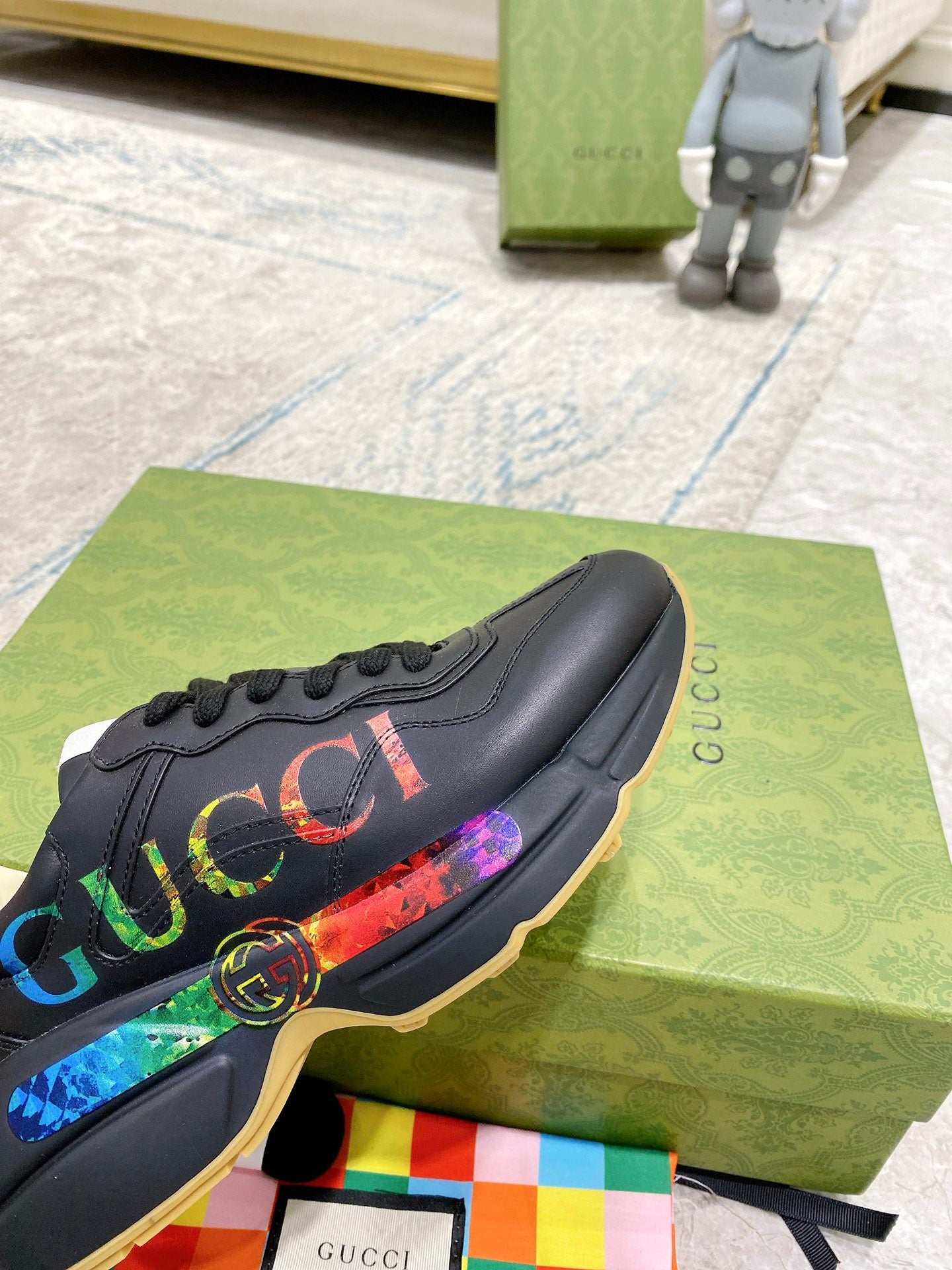 Black Gucci low-top sneaker with multicolor web logo stripe and round emblem