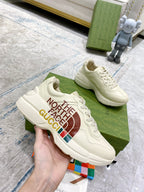 White lace-up sneakers on green box, “THE NORTH FACE GUCCI” logo on side.
