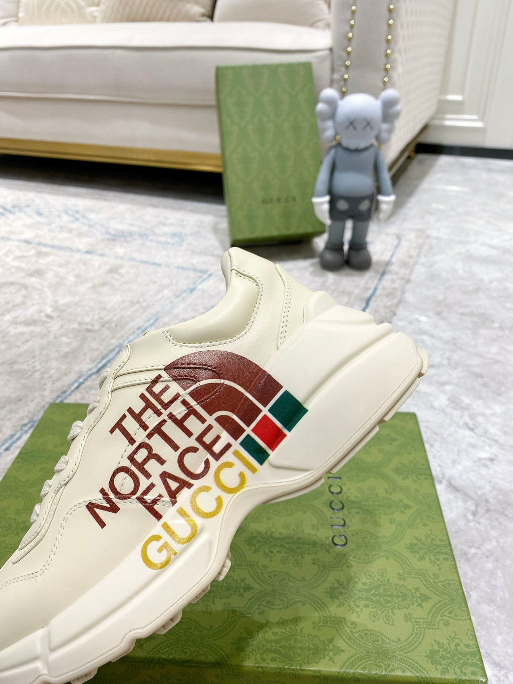 White slide-on sneaker style with side graphic “THE NORTH FACE GUCCI”.