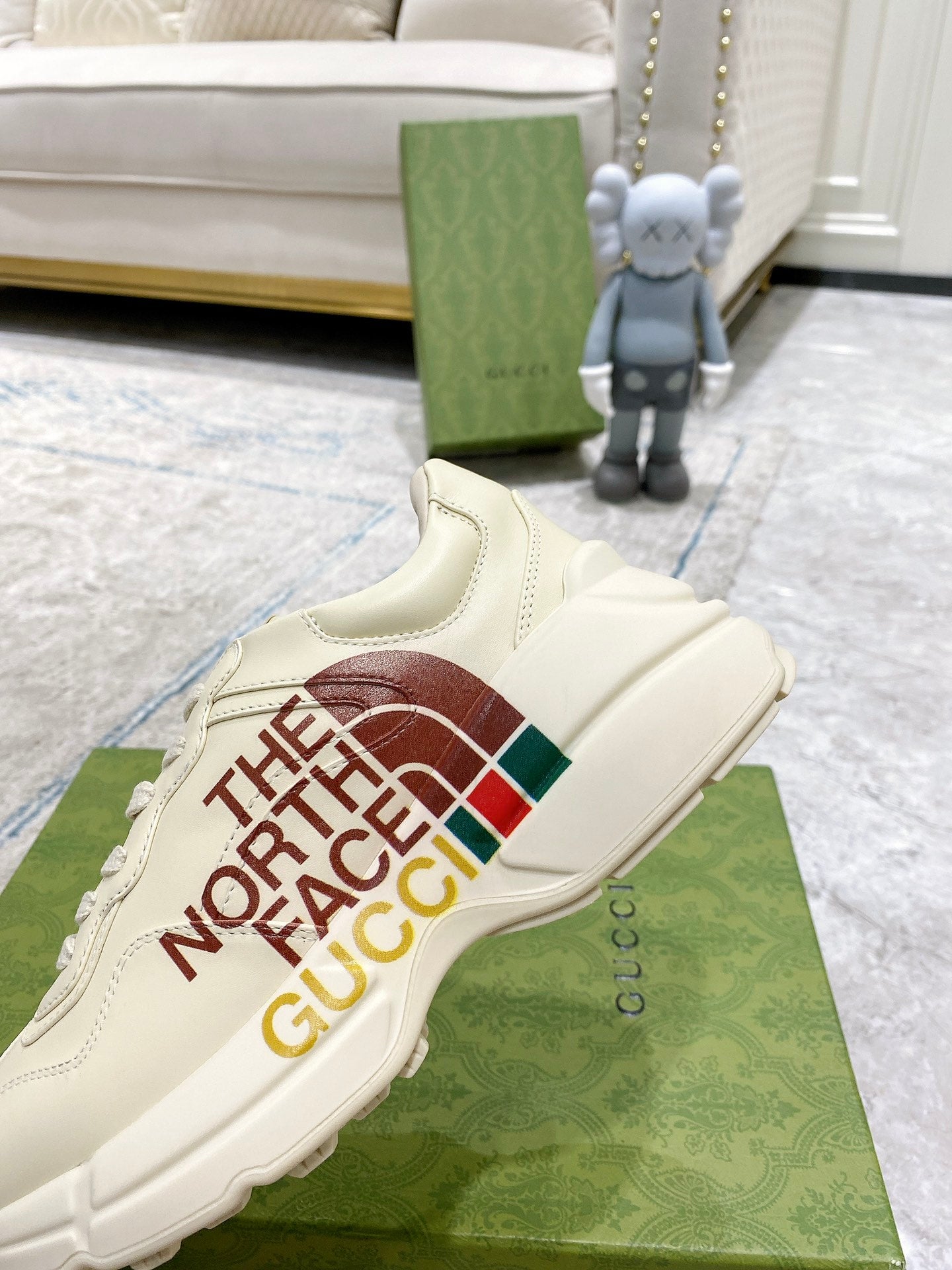 White slide-on sneaker style with side graphic “THE NORTH FACE GUCCI”.