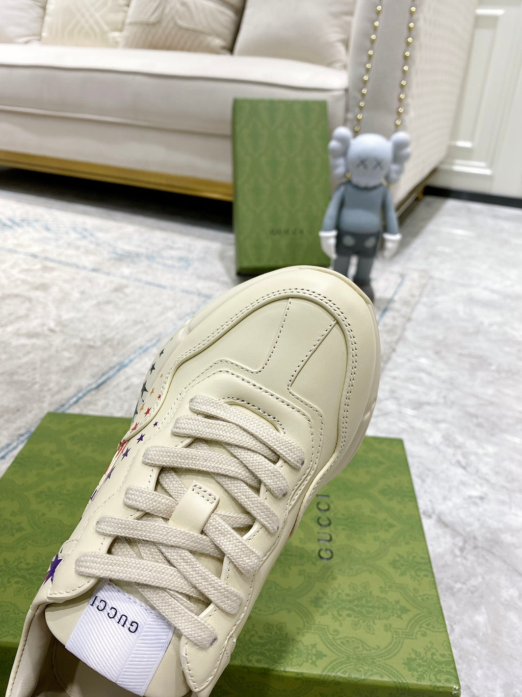 White sneaker heel and laces on green box, textured leather with stitching