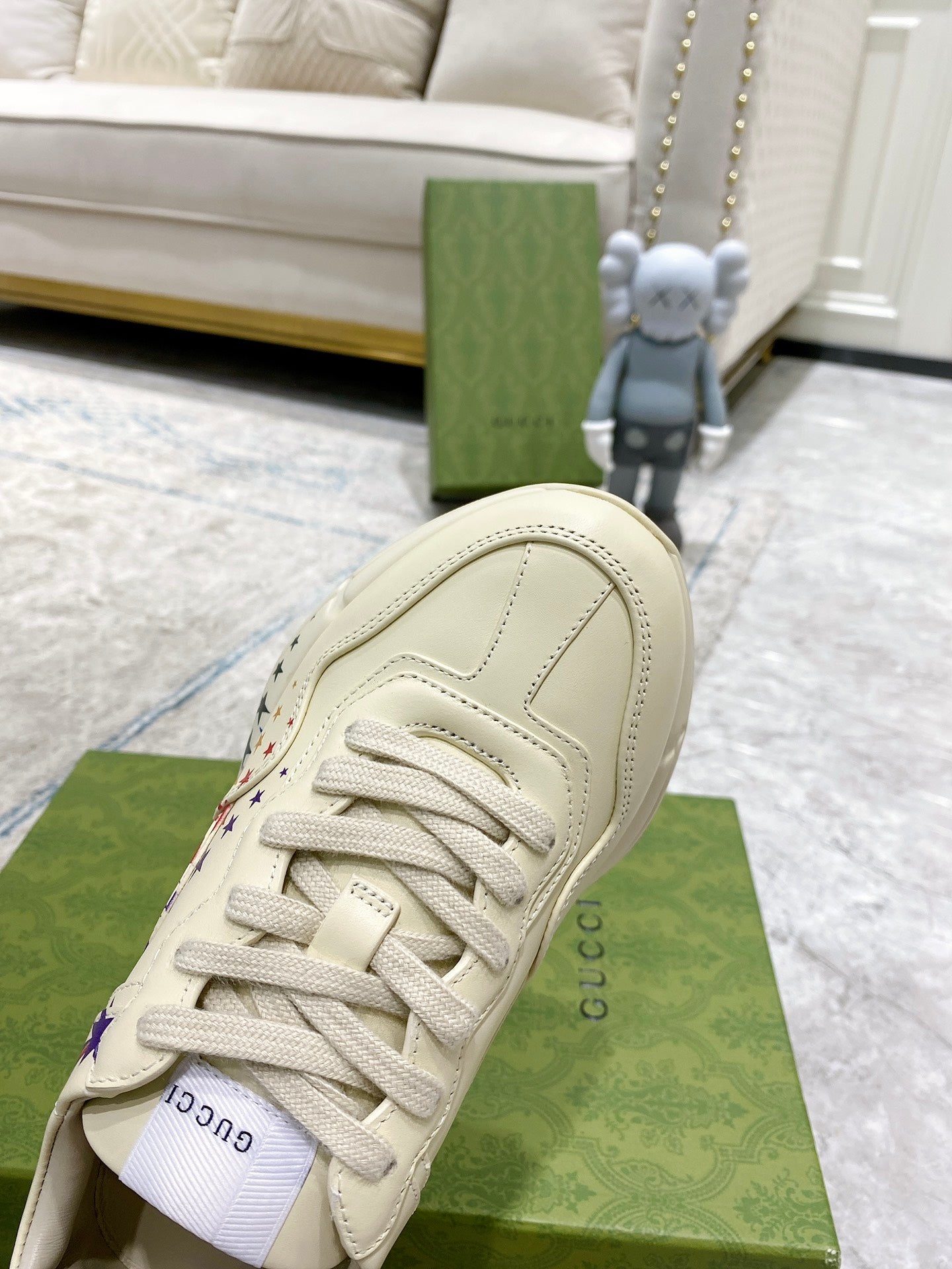 White sneaker heel and laces on green box, textured leather with stitching