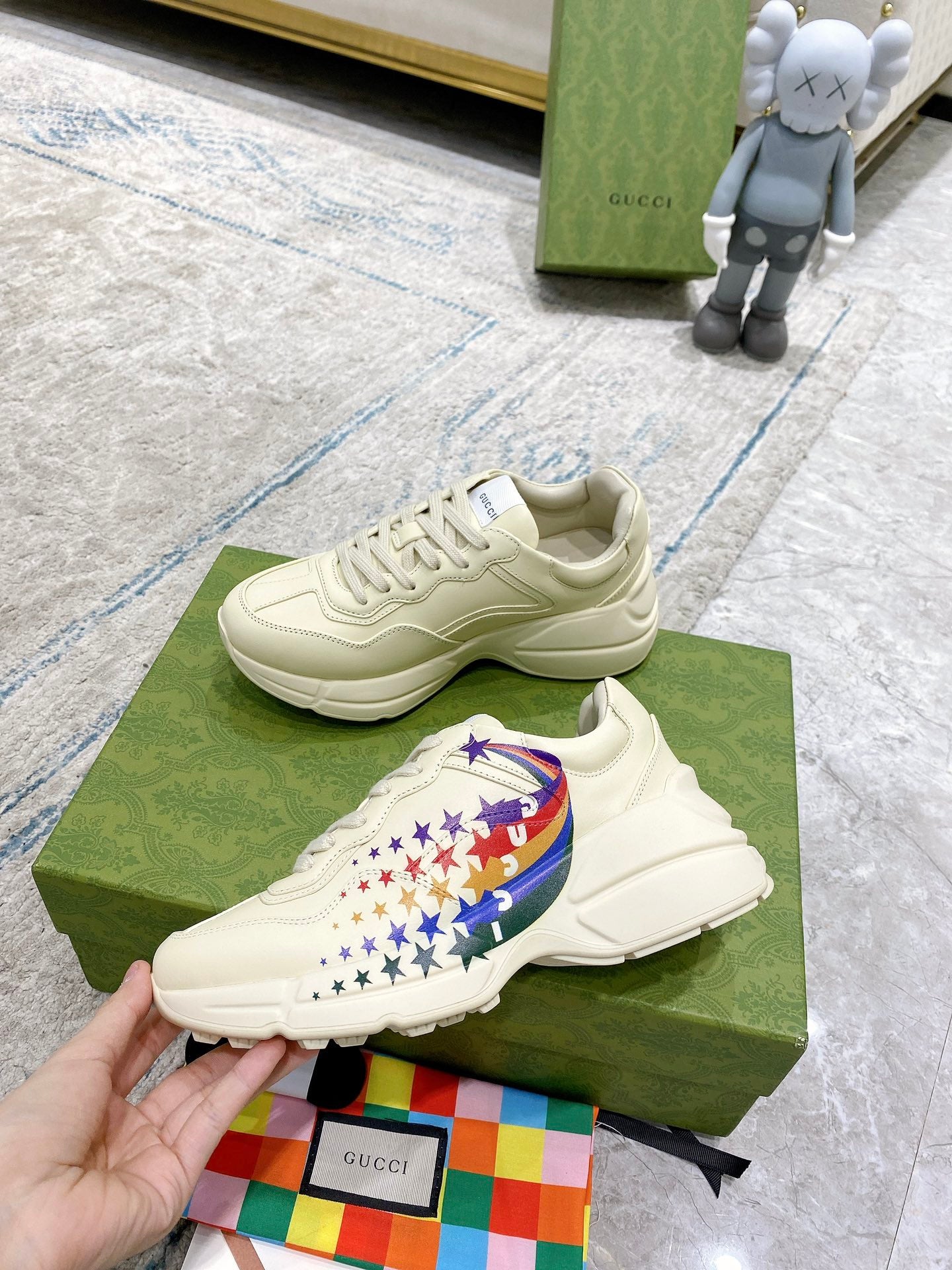 White unisex sneakers with star-and-flag side detail, shown on box