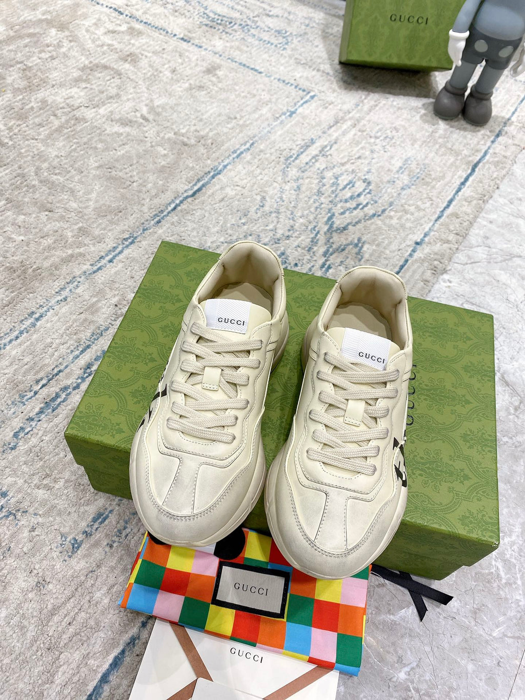 Cream Gucci unisex sneakers pair with white laces and embossed logo details