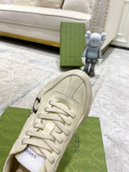 Cream Gucci unisex sneakers close-up of laces, toe seam, and rubber sole