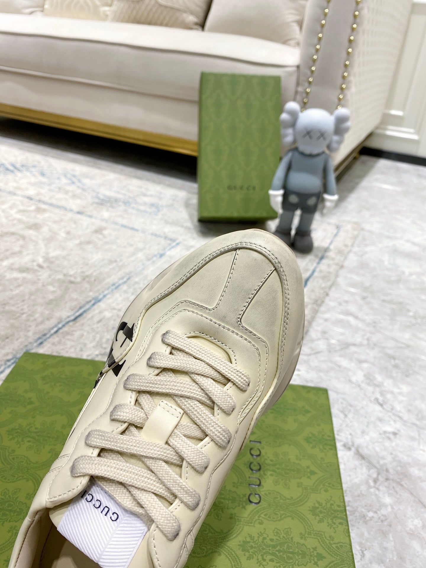 Cream Gucci unisex sneakers close-up of laces, toe seam, and rubber sole