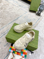 Cream Gucci unisex sneakers with black side emblem and white laces, chunky sole
