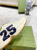 Cream sneakers with navy 25 graphic on side, side-angle view