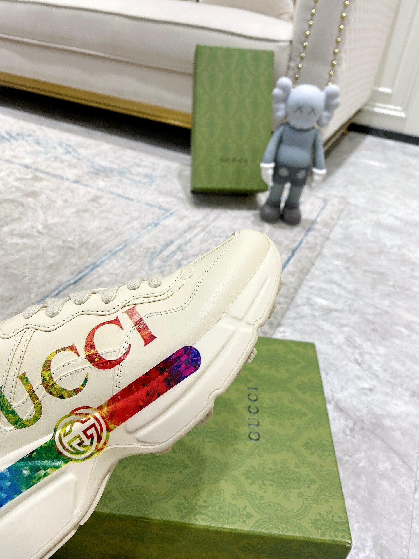 Gucci unisex luxury sneaker close-up, white with multicolor logo stripe on side