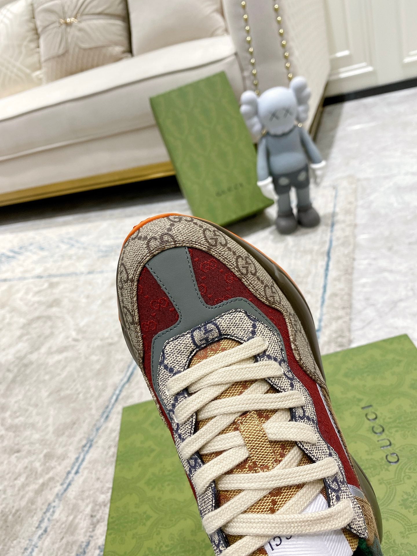 Gucci GG sneaker close-up: beige canvas with red accents, white laces, green lining