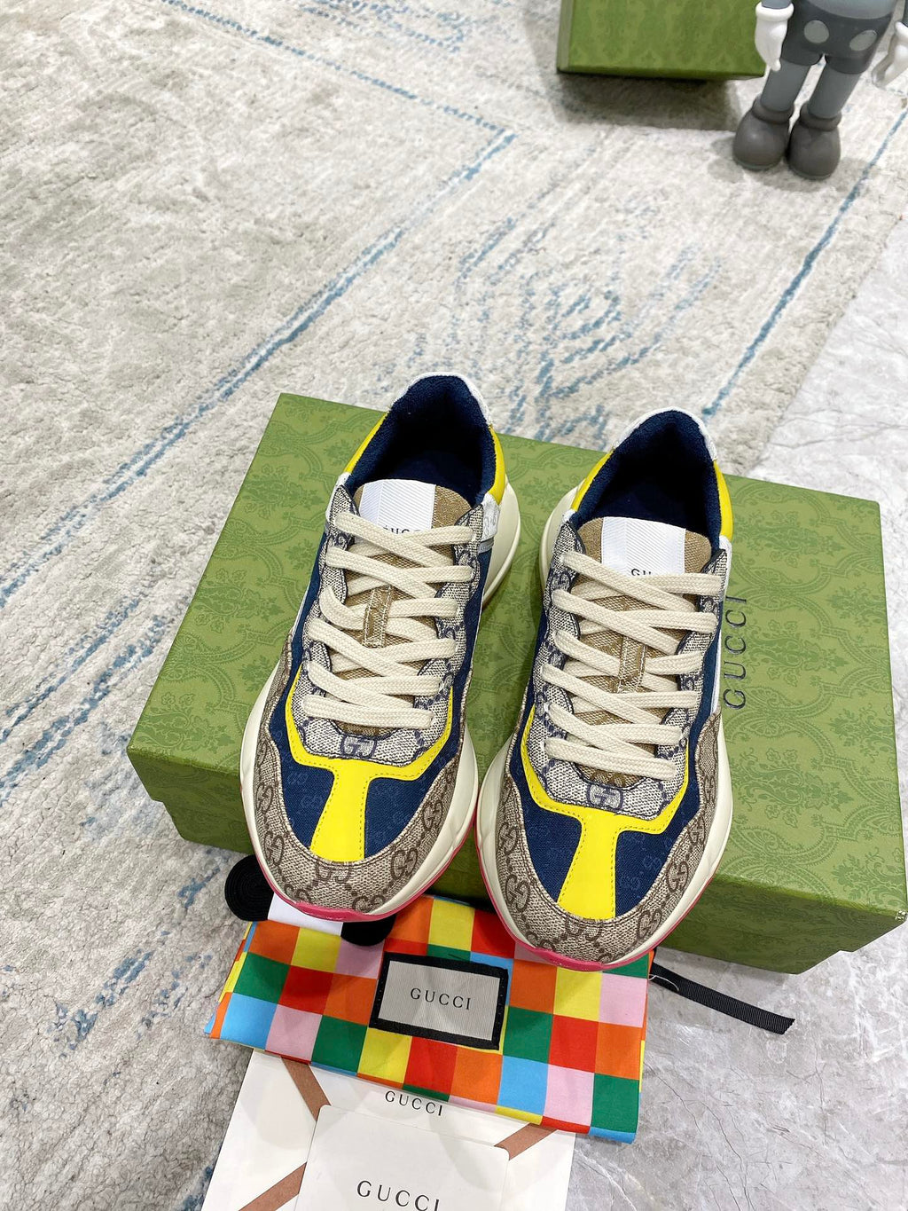 Gucci unisex sneakers, front view: navy and yellow accents with GG-print uppers