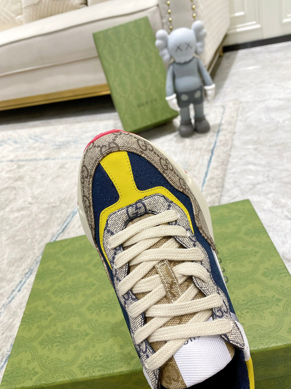 Gucci unisex sneaker close-up, heel and laces: GG canvas with navy and yellow trim