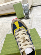 Gucci unisex sneaker close-up, heel and laces: GG canvas with navy and yellow trim