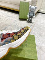 Side view of canvas sneaker with multicolor GG print and white lace-up upper