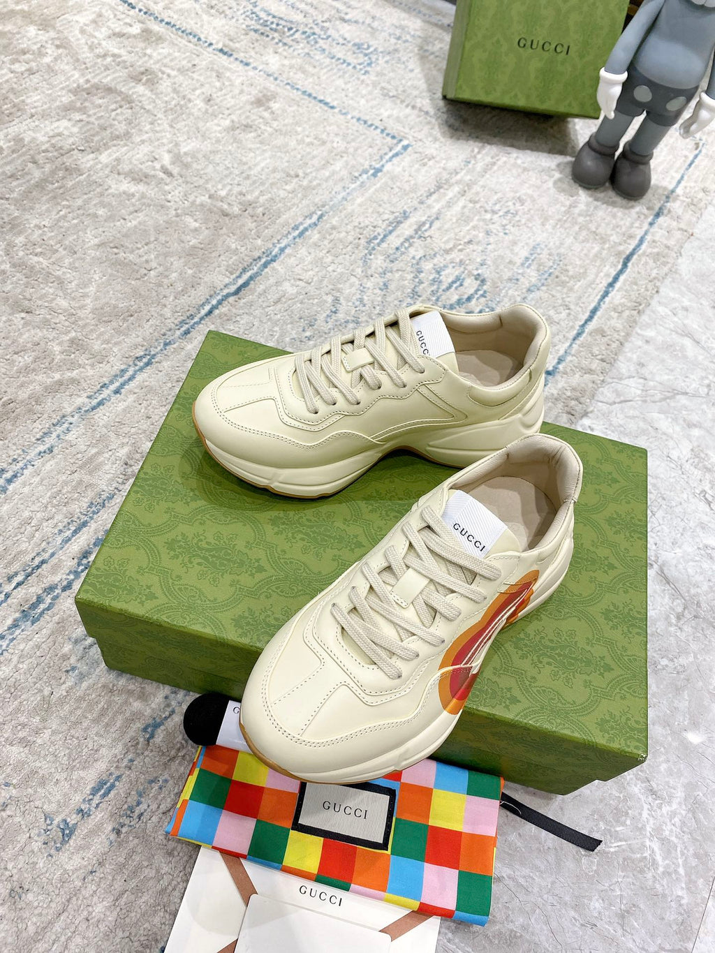 White Gucci unisex lace-up sneaker on green box, stitched details and heart stripe