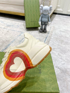 White Gucci unisex sneaker close-up with side heart graphic and gum outsole