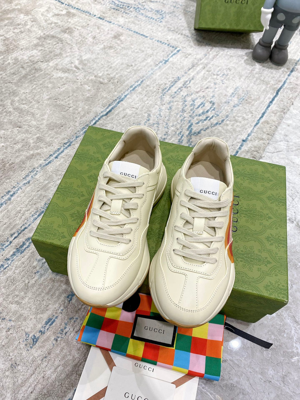 White Gucci unisex lace-up sneakers on green boxes, heart logo side panels