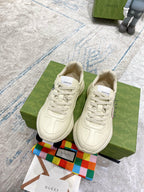 Cream Gucci low-top sneakers with stitched details and red-and-green GG emblem