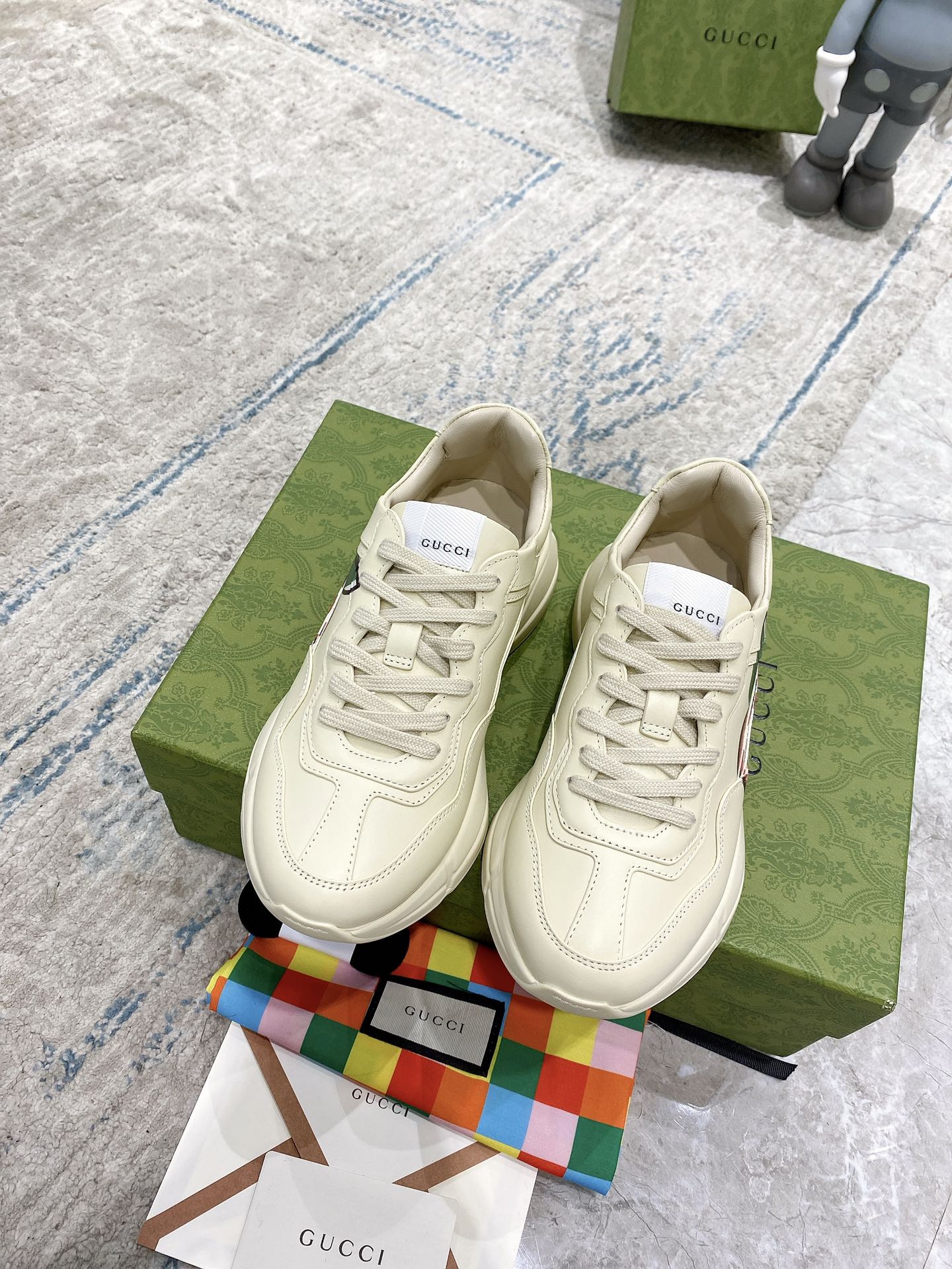 Cream Gucci low-top sneakers with stitched details and red-and-green GG emblem