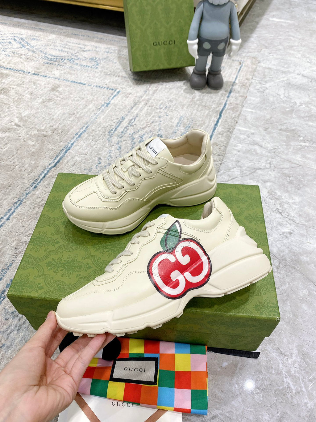 Cream Gucci sneakers with red-and-green GG logo and lace-up front