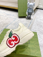 Cream Gucci sneaker with red-and-green GG logo on side and lace-up top