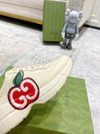 Cream Gucci sneaker close-up with red-and-green GG logo on the side