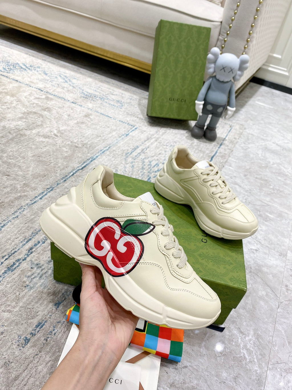 Cream Gucci sneakers pair on display with red-and-green GG logo on side