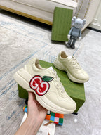 Cream Gucci sneakers pair on display with red-and-green GG logo on side
