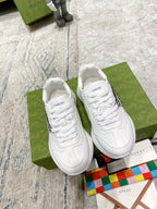 White Gucci unisex sneakers, front view with lace-up detailing and side cat graphic.
