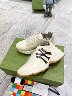 Gucci unisex sneakers with light cream uppers, black NY logo and blue patterned lining