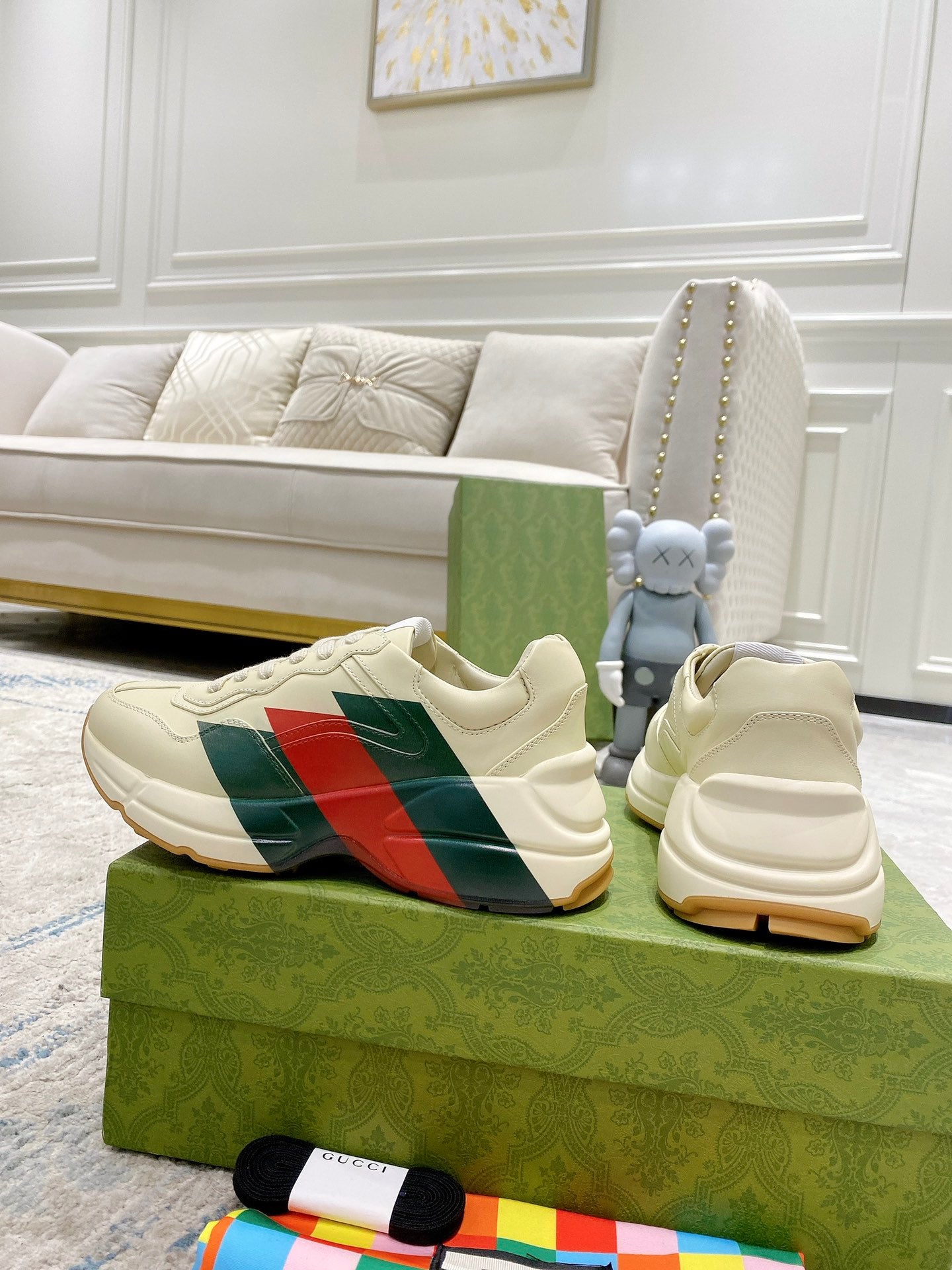Unisex white sneakers set on box; side stripe panel and lace-up closure visible.