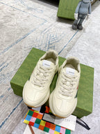 Pair of unisex white lace-up sneakers with multicolor stripe detail and logo patch.