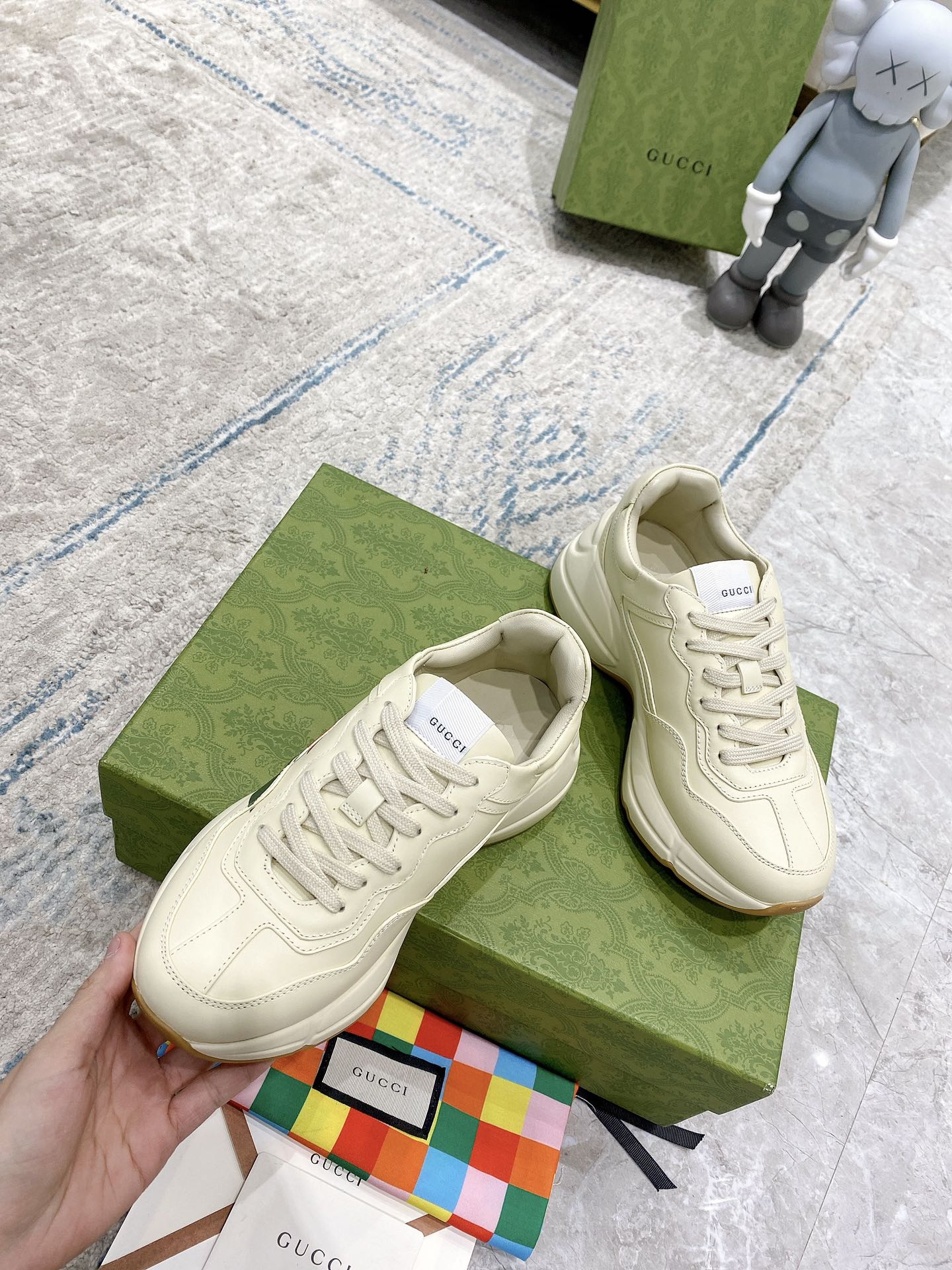 Unisex white lace-up sneakers with multicolor stripe detail and cushioned low profile.