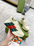 Unisex white sneakers with green and red stripe panel, lace-up front view.