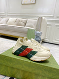 Unisex white leather sneakers with red and green stripe panel, lace-up front.