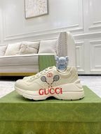Cream unisex Gucci sneakers, lace-up design with red GUCCI logo on the side