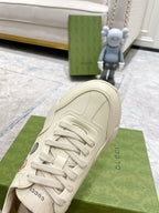 Cream unisex Gucci sneaker with lace-up front and stitched panel details