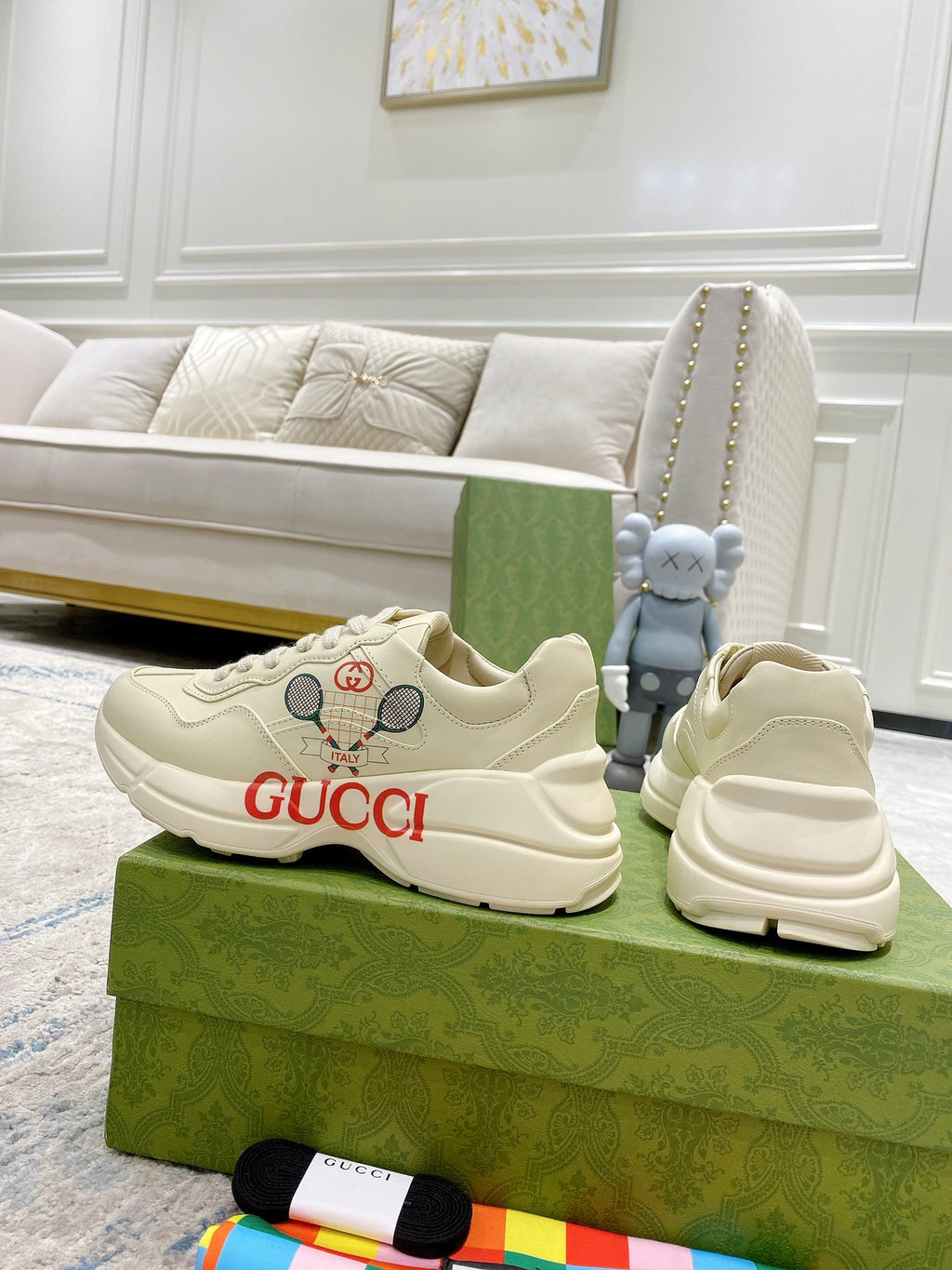 Cream unisex Gucci sneakers with red GUCCI lettering and perforated detail