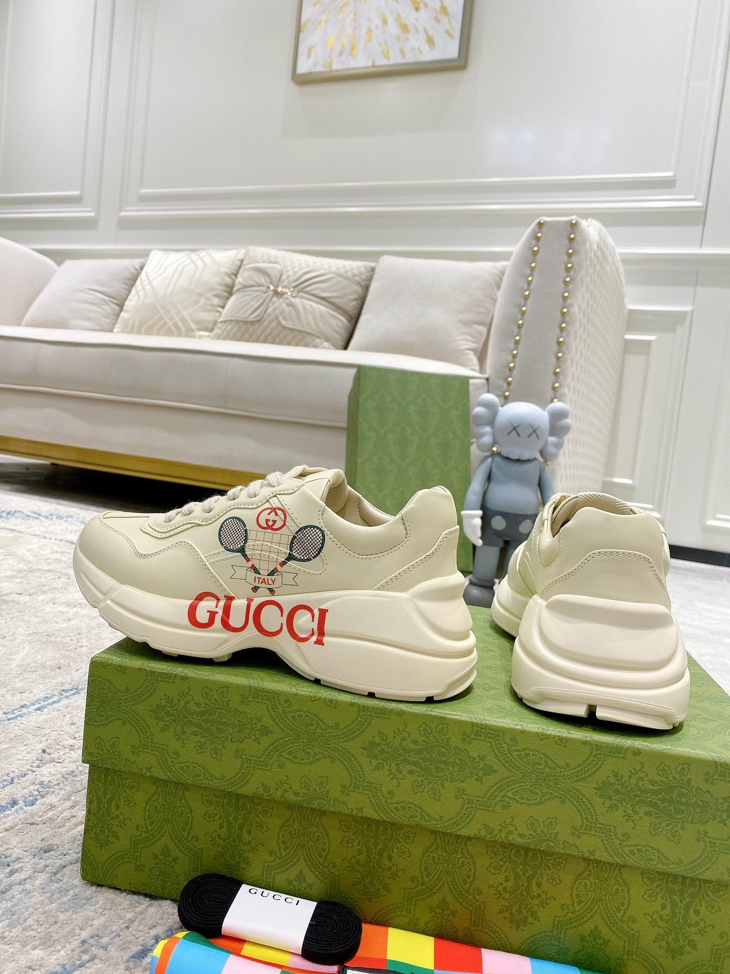 Cream unisex Gucci sneakers with red GUCCI lettering and perforated detail