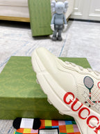 Cream unisex Gucci sneakers with side tennis graphic and red GUCCI lettering