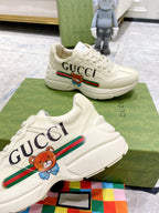 Gucci unisex luxury sneakers, white with large GUCCI side text and bear patch