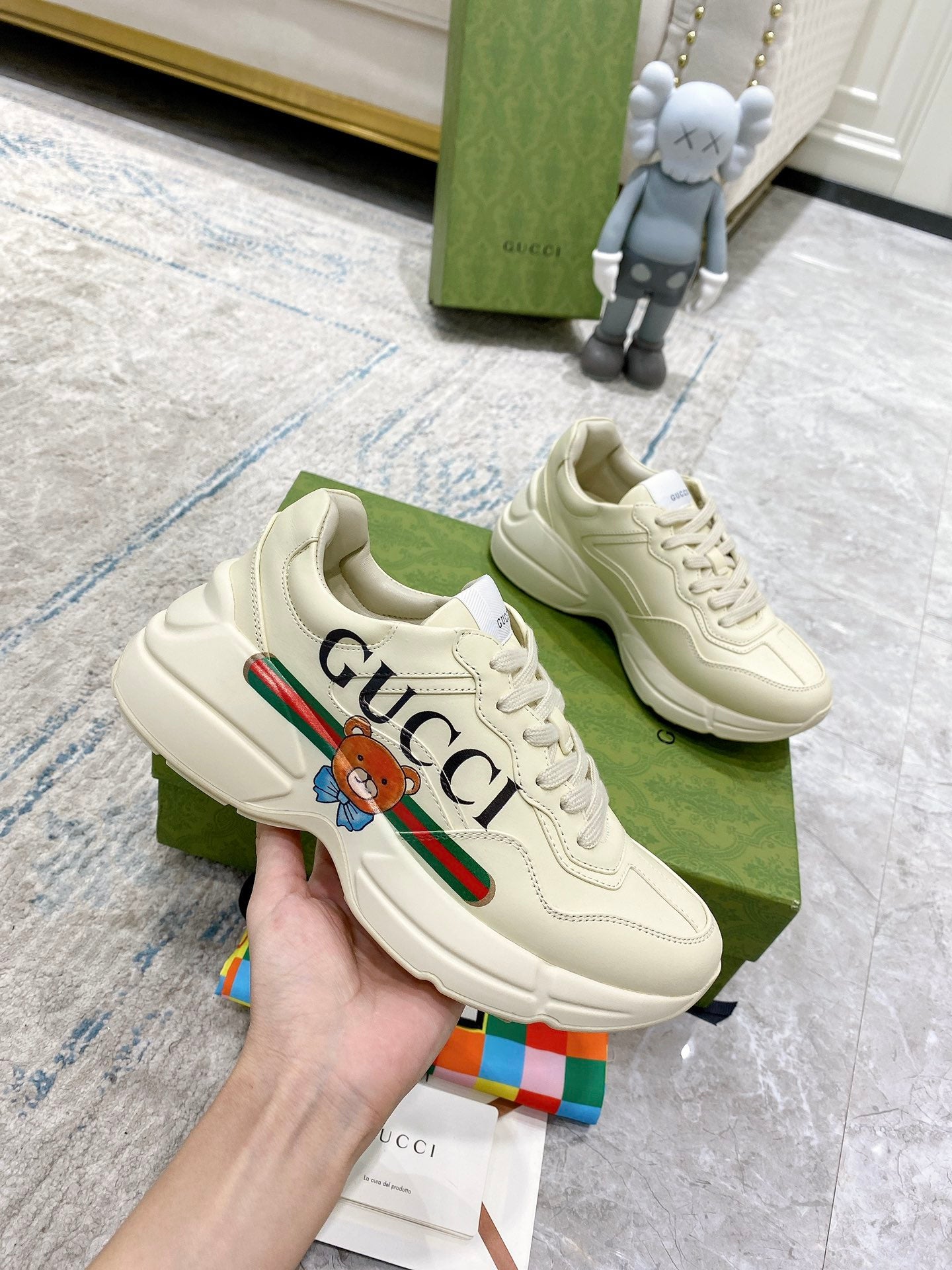 Gucci unisex luxury sneakers, white close-up with GUCCI stripe and bear patch