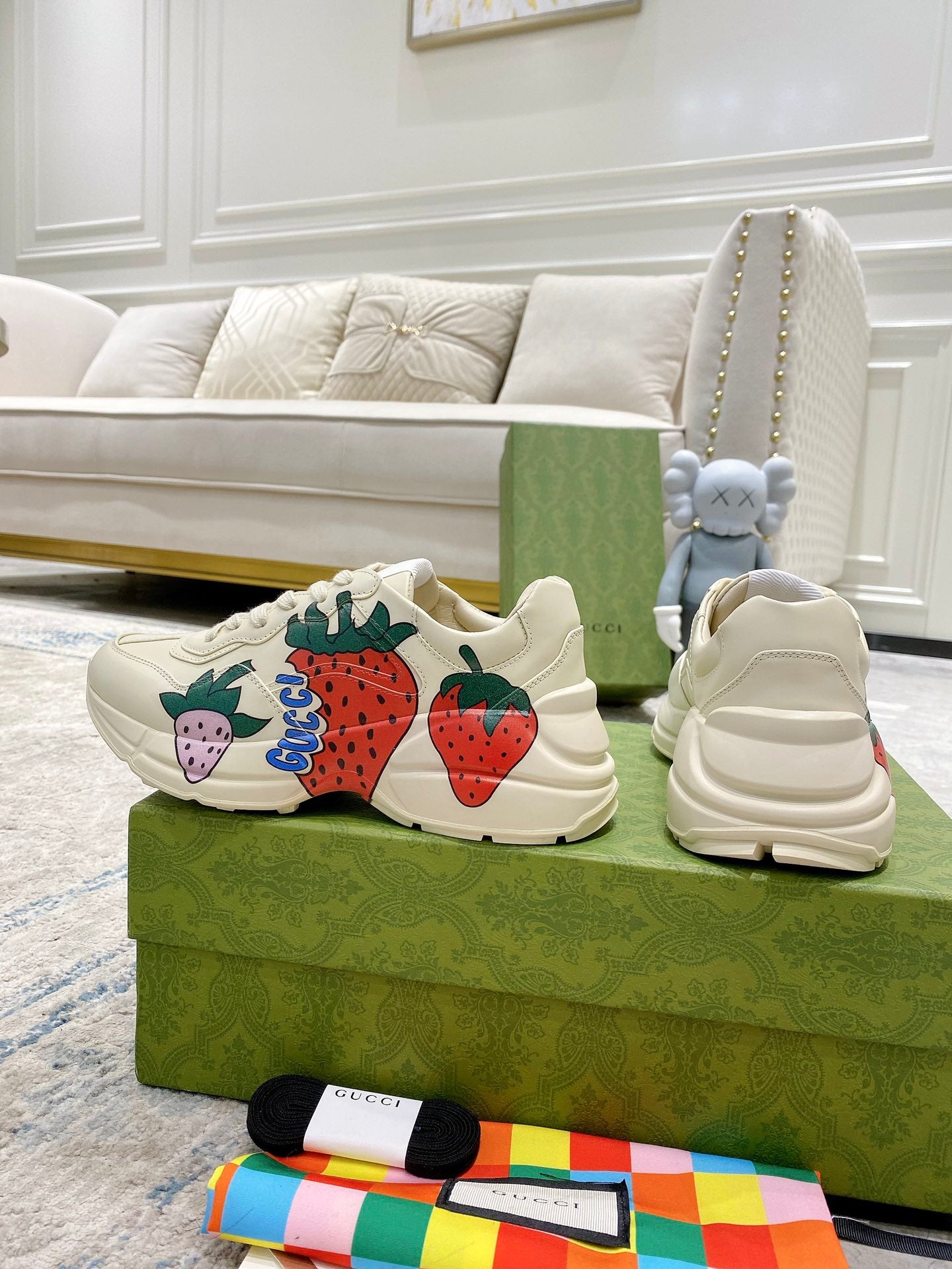 Gucci unisex sneakers set: cream uppers with strawberry graphic; white lace-up and heel view.