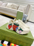 Gucci unisex sneakers, cream leather with strawberry graphic and blue detail, lace-up.